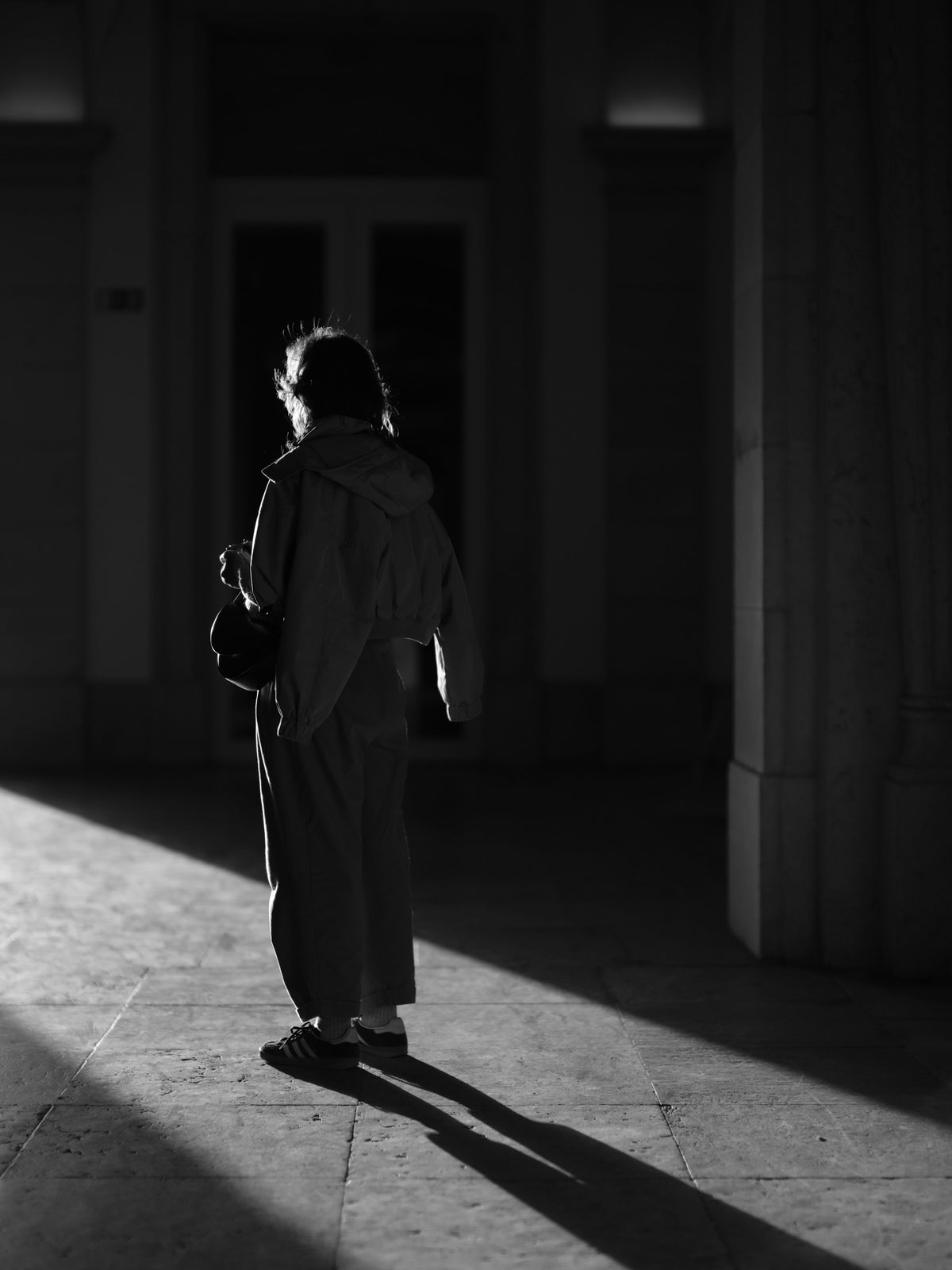 figure walking through light and shadow