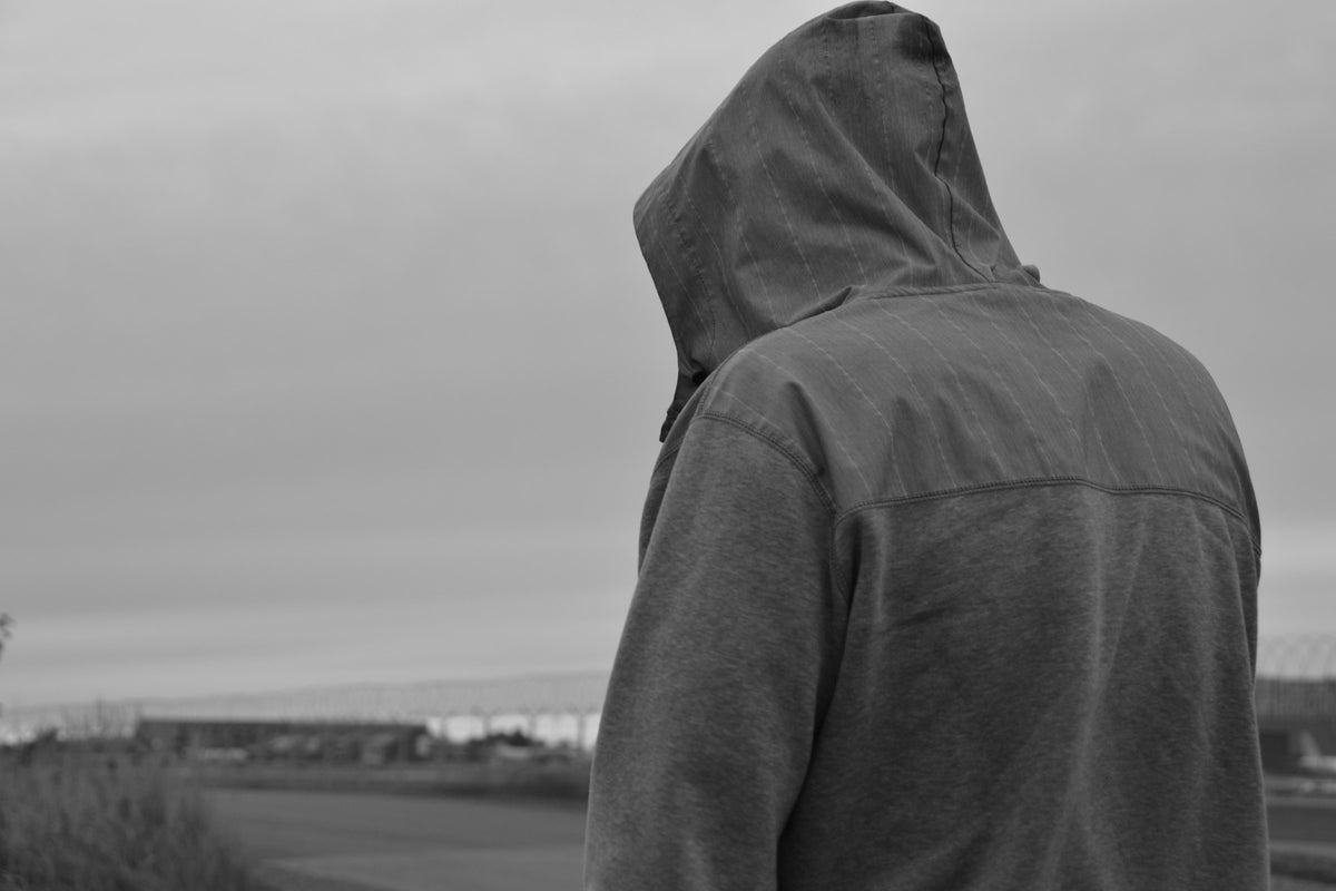 hooded figure looking out at dusk