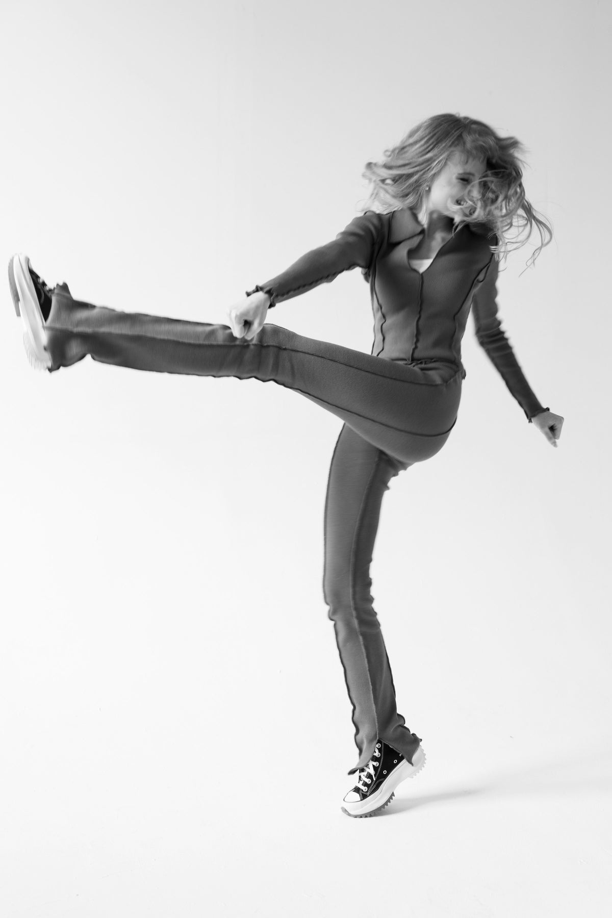 woman kicking in a fitted set, studio